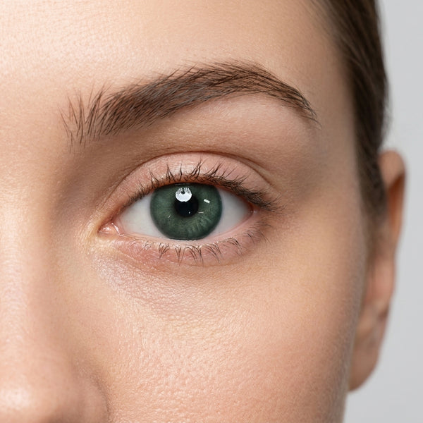 Orama Emerald Aura colored contact lens shown on a single eye